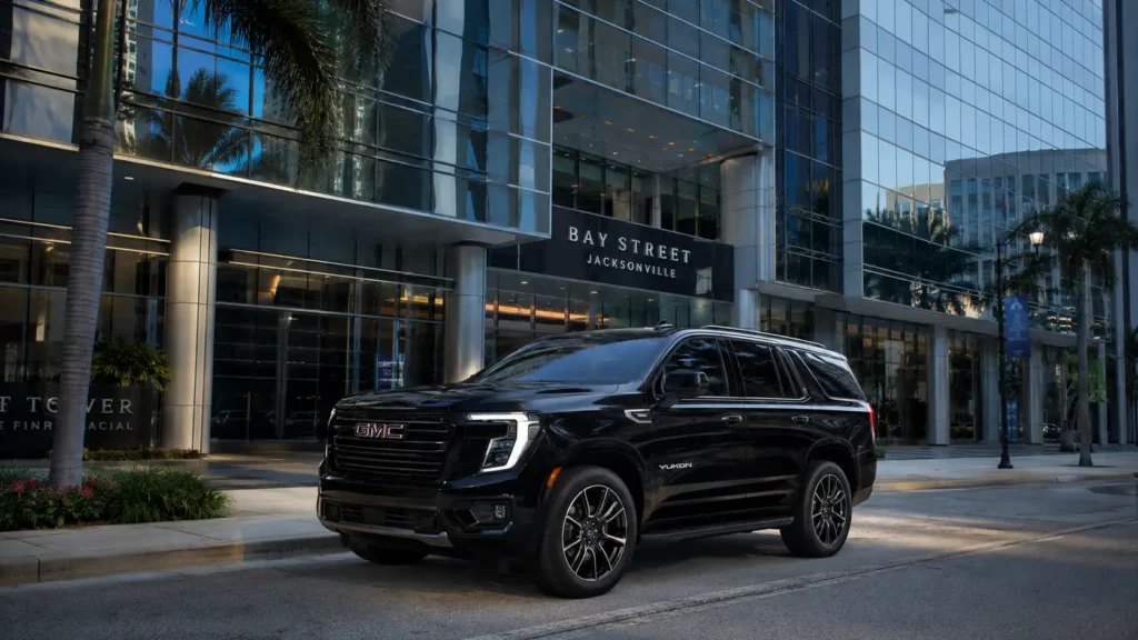 A premium full-size luxury black SUV arriving at a modern high-rise corporate office building in downtown Jacksonville, Florida.