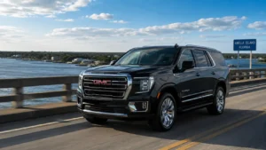 A luxury black GMC Yukon SUV driving smoothly over the scenic A1A bridge connector toward Amelia Island resorts under a bright Florida sun.